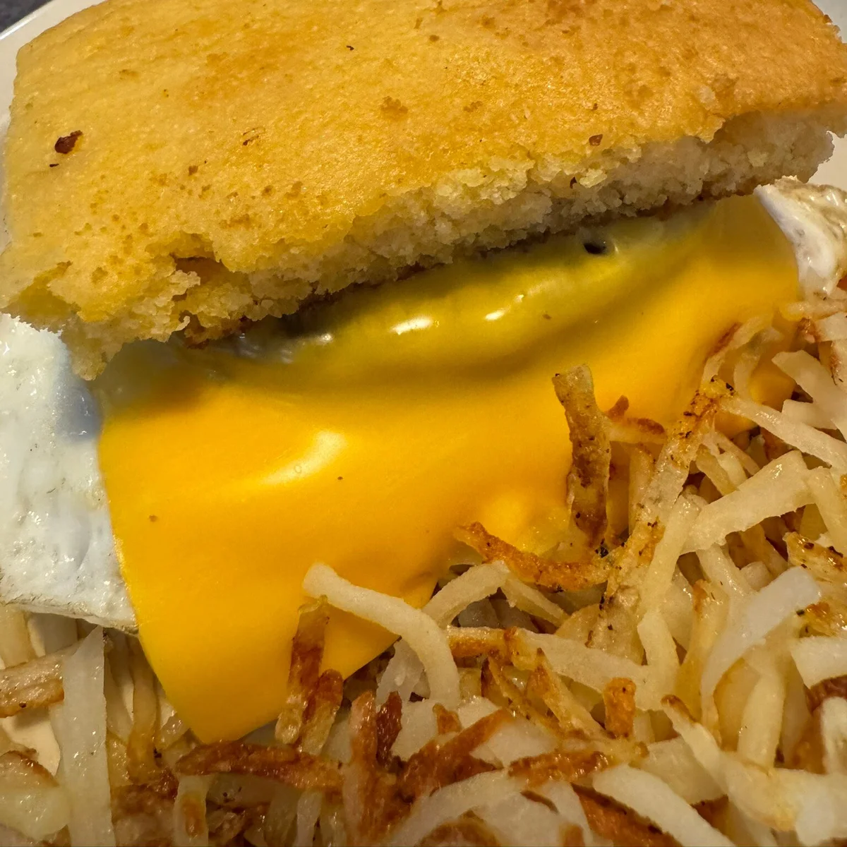 Guest photo of a fried egg sandwich with cheese and hash browns at Sharon’s Homestyle Cookin’